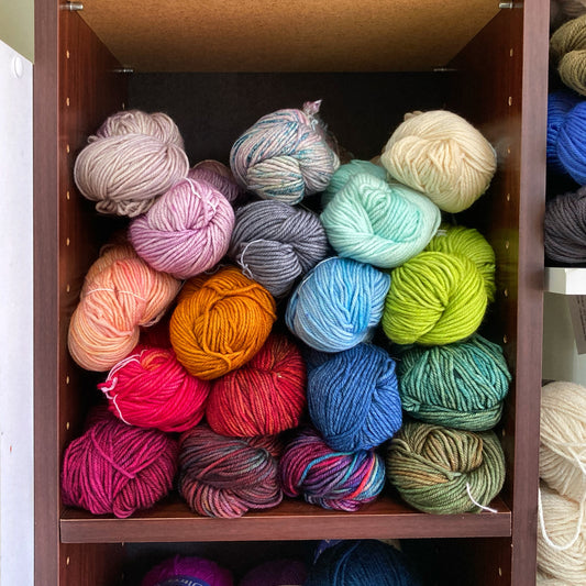 Malabrigo Rios yarn in various colors on a shelf, for sale at Hillsborough Yarn Shop, NC, USA.