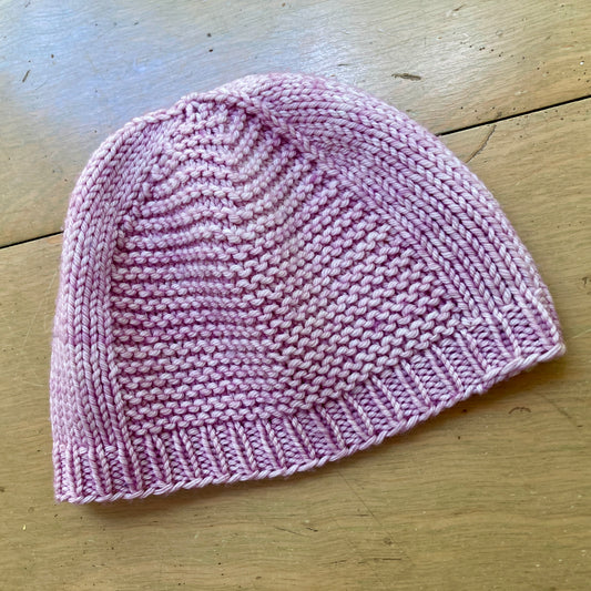 Sample of a hat knit in Malabrigo Rios yarn in the color Valentina, a light pink.