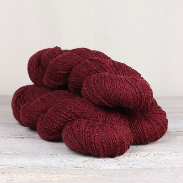 3 skeins of deep red Fibre Co. Lore yarn.