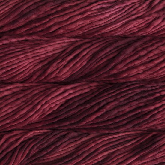 Close up on burgundy skein of Malabrigo Rasta yarn.