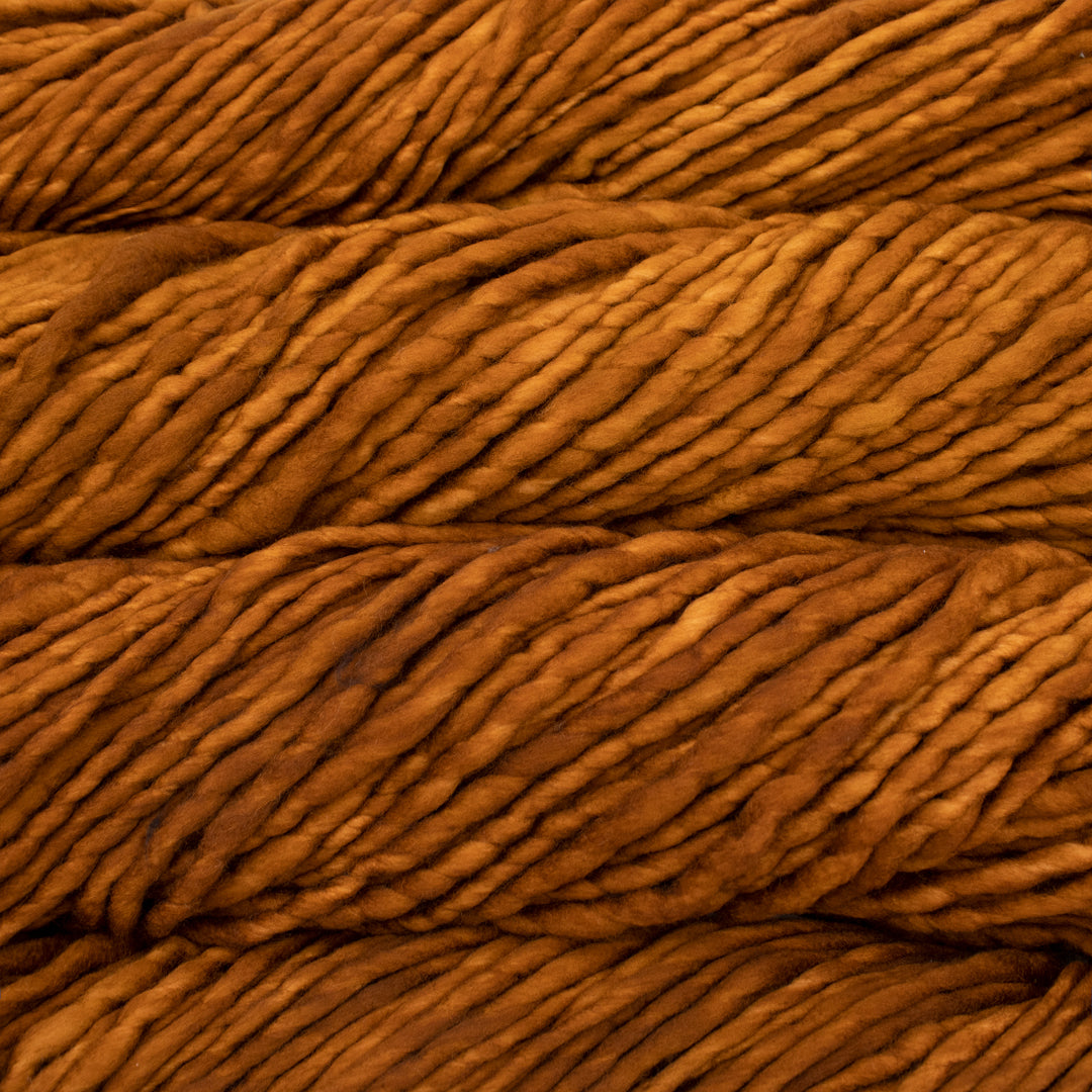 Close up on burnt orange skein of Malabrigo Rasta yarn in color Caramel.