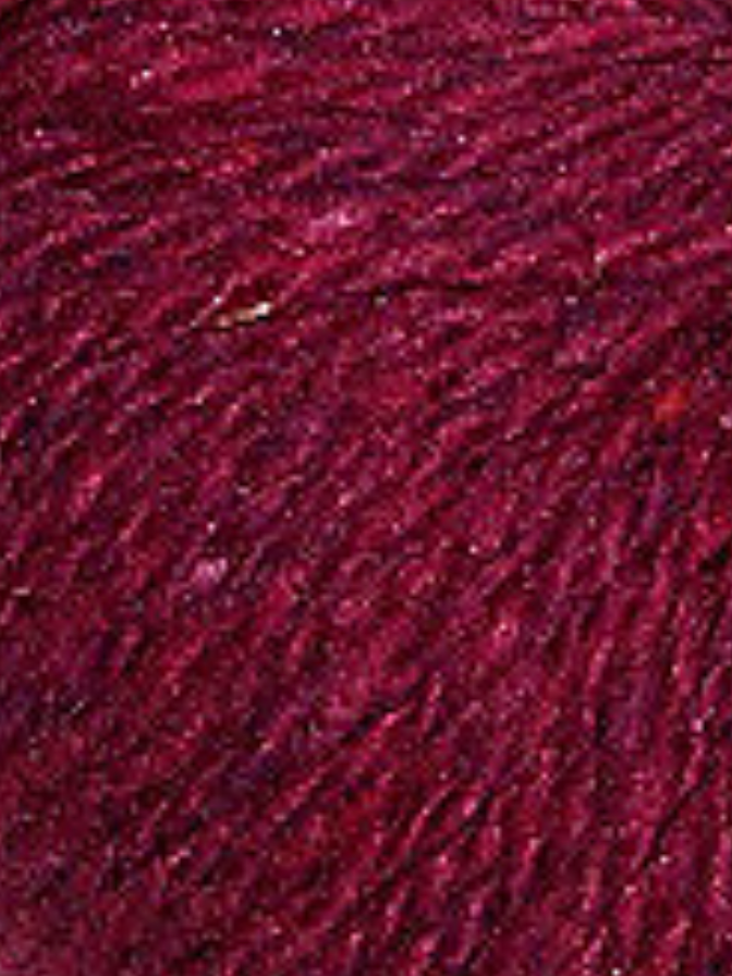 Close up on a dark burgundy tweed ball of Queensland Kathmandu Aran yarn.