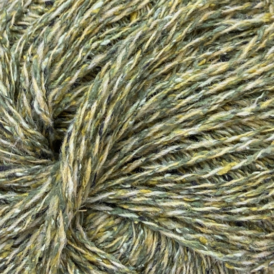 Close up on ball of Simply Shetland Silk & Lambswool yarn in tweedy grass green, colorway Melgund