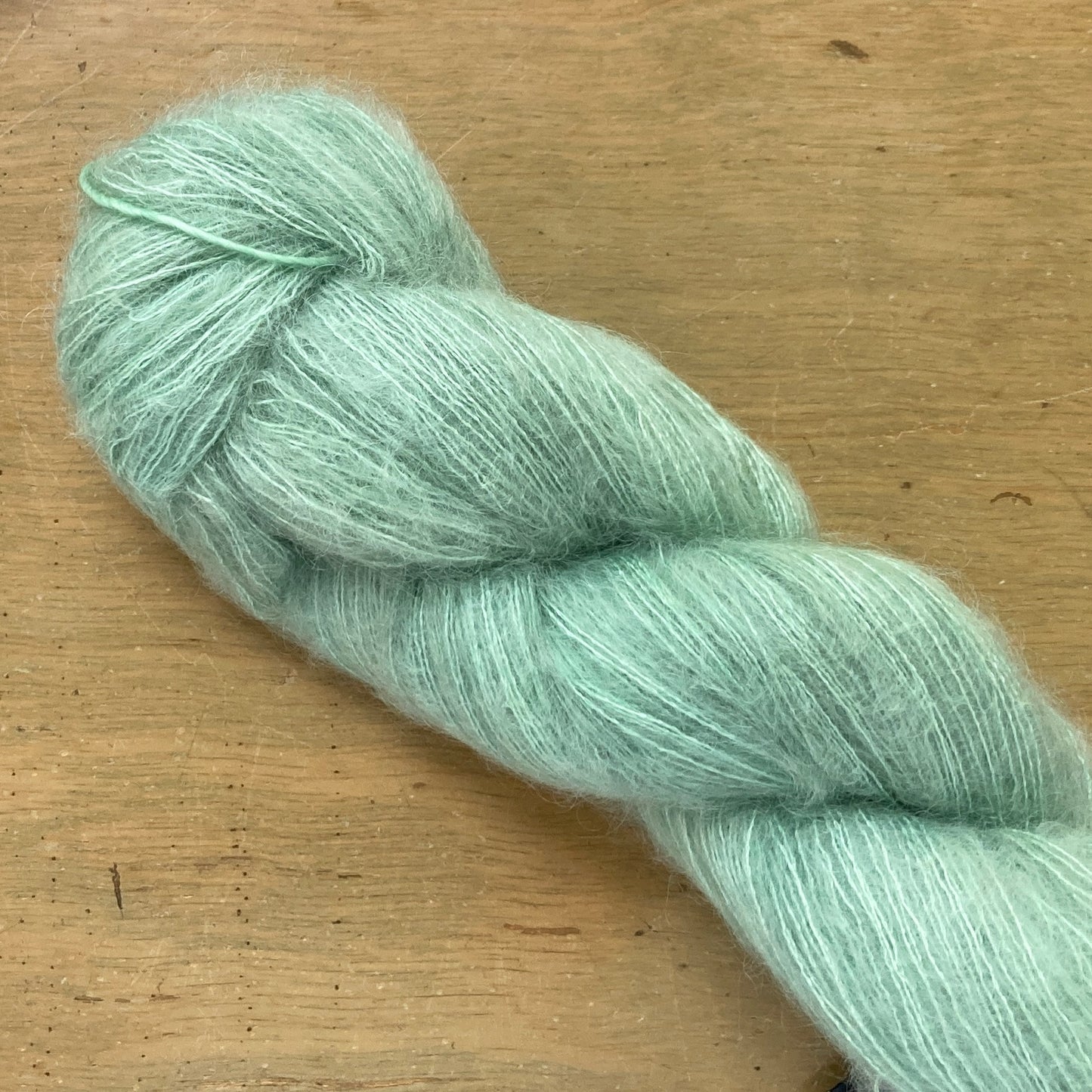 Mint green skein of Fleece Artist / Hand Maiden Superkid Silk yarn, colorway Lichen