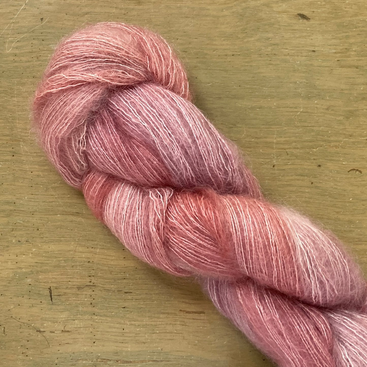 Rose Gold skein of Fleece Artist / Hand Maiden Superkid Silk yarn.
