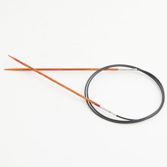Orange circular knitting needles, connected by a black cord.