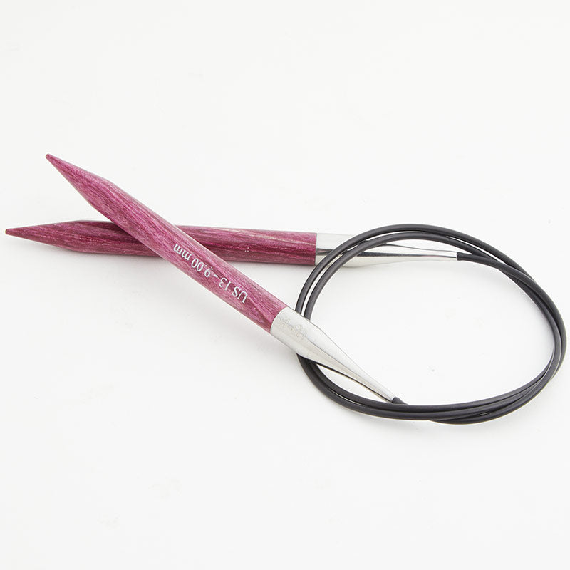 Pink circular knitting needles, connected by a black cord.