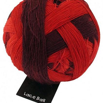 One ball of Schoppel-Wolle lace merino yarn in ombré red and maroon.