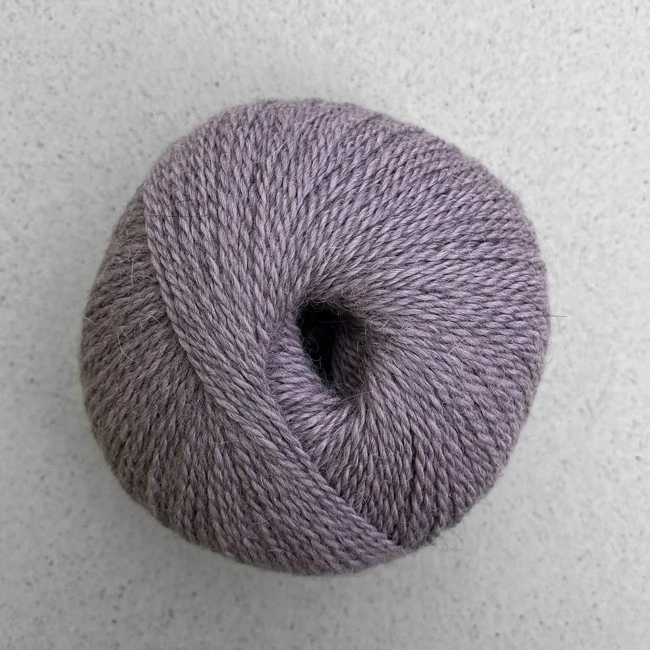 Ball of heathered lavender grey Pascuali Balayage yarn. 