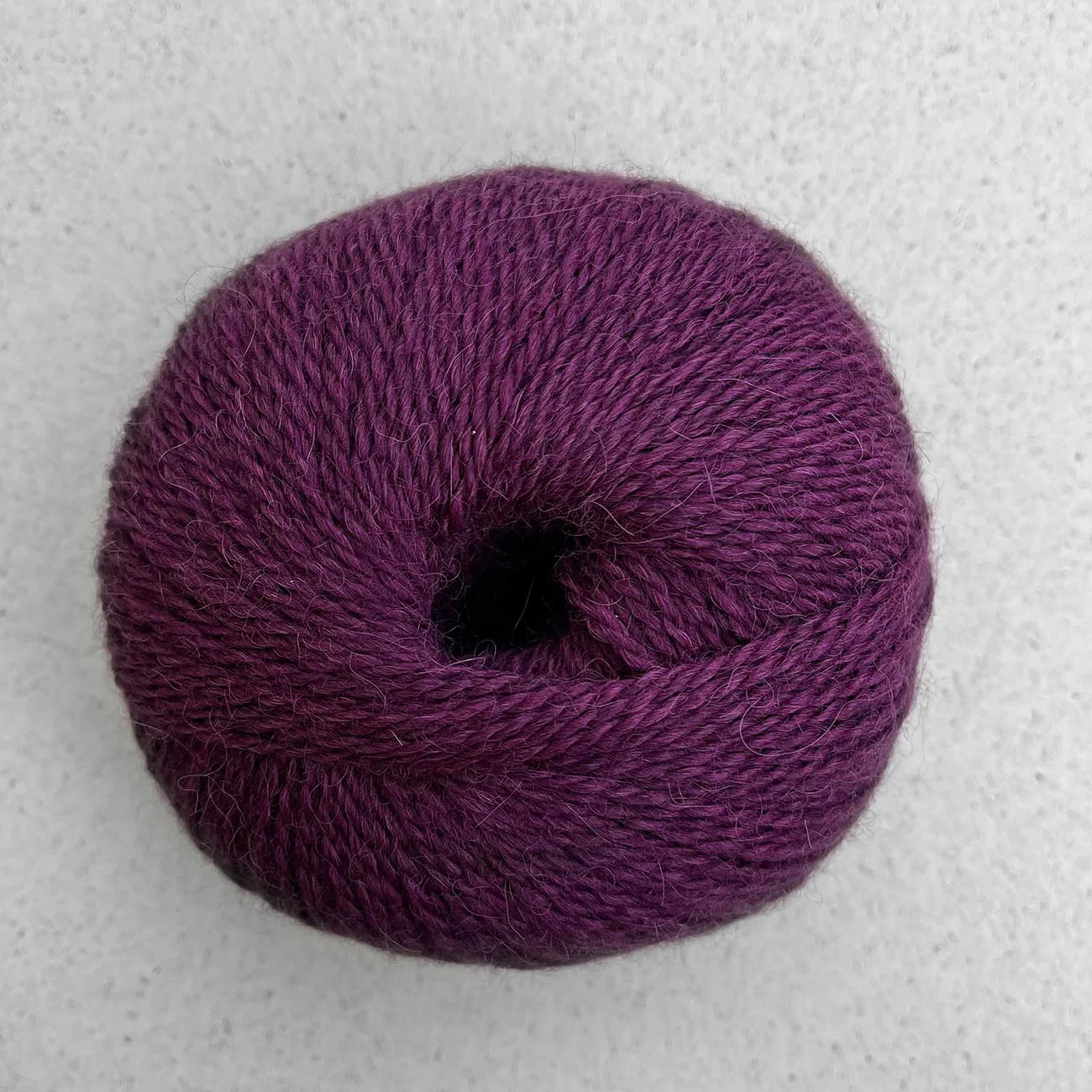 Ball of burgundy Pascuali Balayage yarn. 