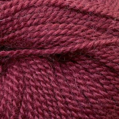 Close up on a ball of burgundy Jo Sharp Alpaca Kid Lustre yarn. 