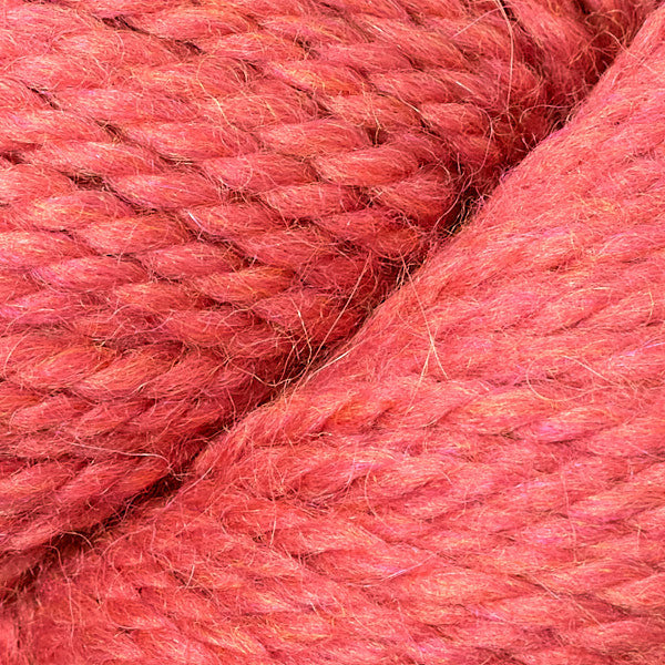 Close up on skein of Berroco Ultra Alpaca Chunky yarn in coral. 