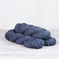 3 skeins of purplish blue Fibre Co. Acadia yarn. 