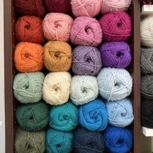 Cubby full of colorful balls of Berroco Ultra Wool yarn, on display at the Hillsborough Yarn Shop.