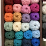 Cubby full of colorful balls of Berroco Ultra Wool yarn, on display at the Hillsborough Yarn Shop.