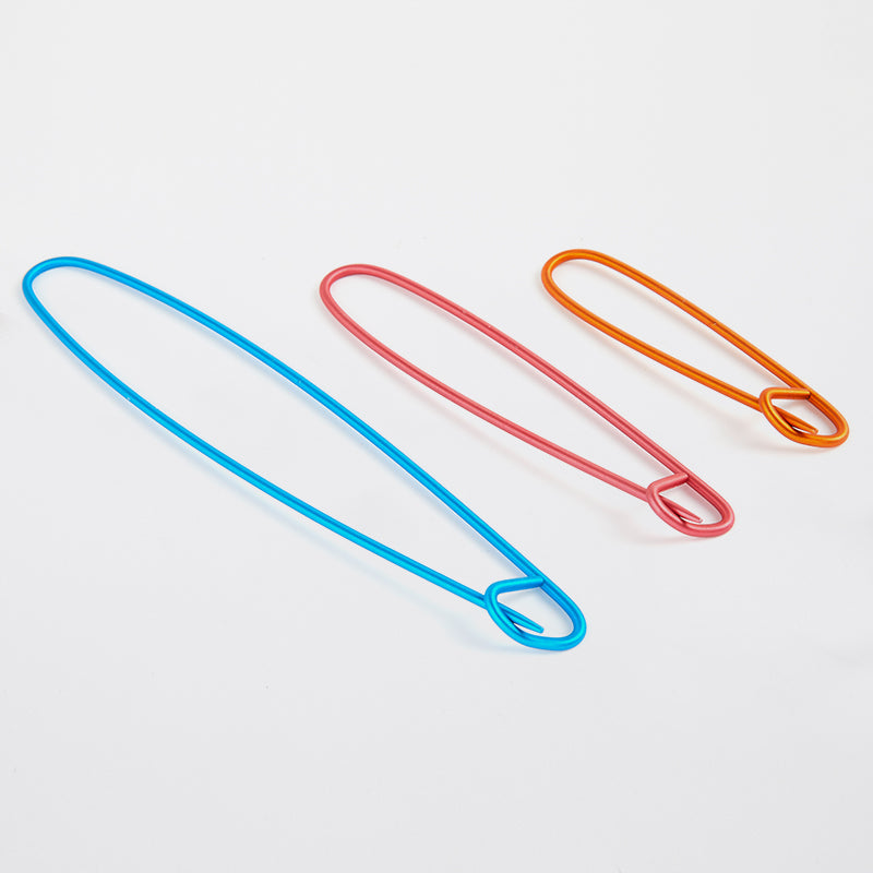 Three colorful aluminum stitch holders in different sizes. 