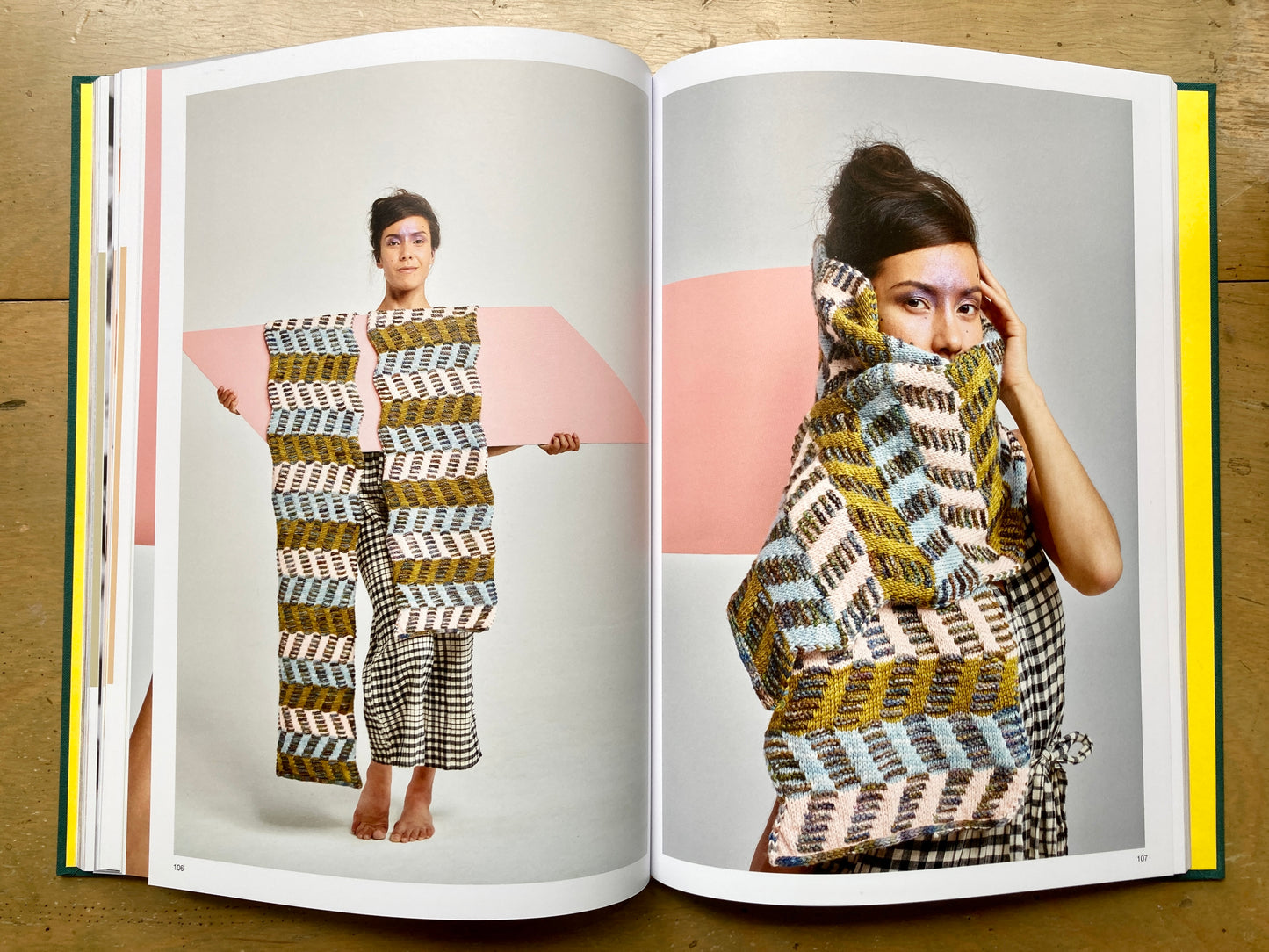 Stephen West’s Painting Shawls book, lying open, showing colorful photos of people modeling shawls. 