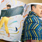 Stephen West’s Painting Shawls book, lying open, showing colorful photos of people modeling shawls. 