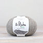 Light heathered gray ball of Fibre Co. & Make Aran yarn. 