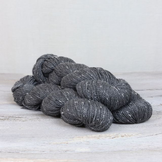 3 skeins of dark gray Fibre Co. Acadia yarn. 