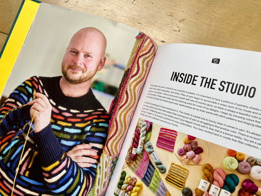 Stephen West’s Painting Shawls book, lying open, showing colorful photos and text. 