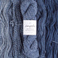 Skeins of denim blue Brooklyn Tweed Dapple yarn. 