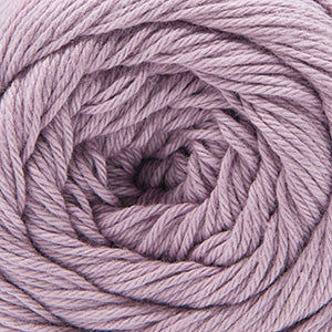 Close up on a semisolid ball of orchid purple Cascade Botanika yarn. 