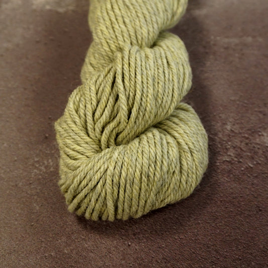 Close up on a skein of light green Kate Davies Designs Àrd-Thìr yarn. 