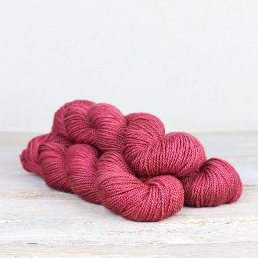 3 skeins of raspberry pink Fibre Co. Acadia yarn. 