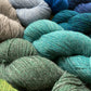 Close up on colorful skeins of Berroco Ultra Alpaca yarn, in shades of blue and green.