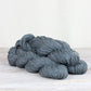 3 skeins of denim blue Fibre Co. Acadia yarn. 