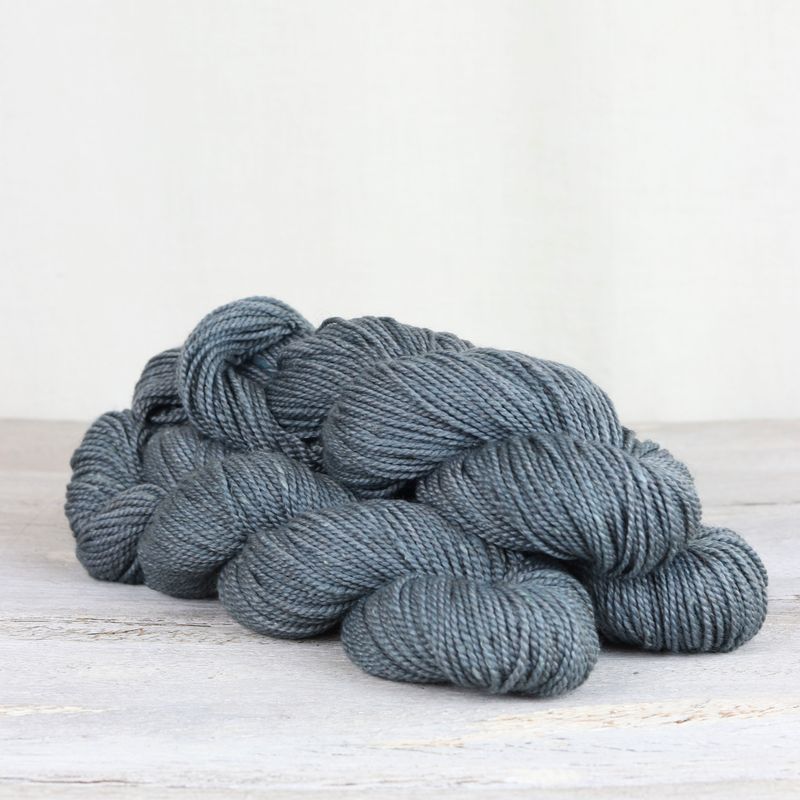 3 skeins of denim blue Fibre Co. Acadia yarn. 