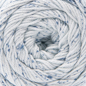 Close up on a speckled ball of white and blue Cascade Botanika yarn. 