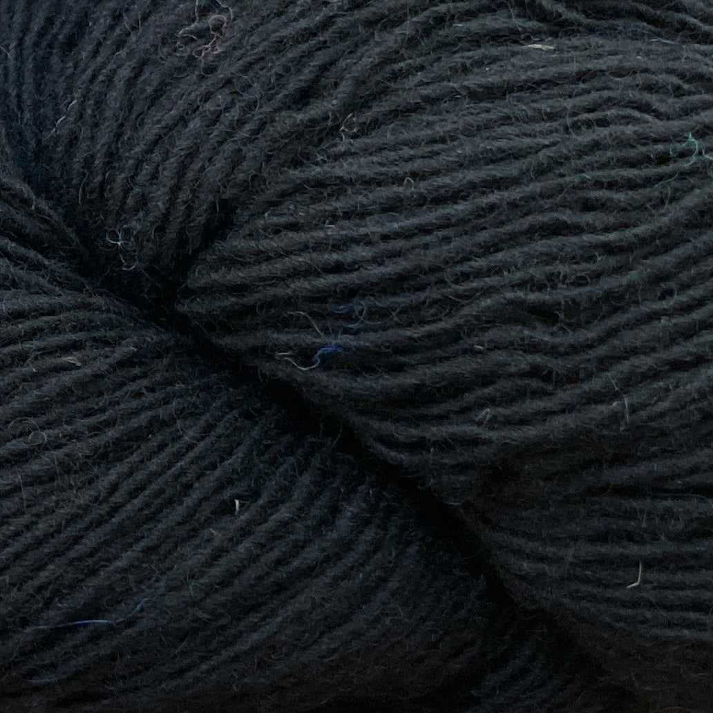 Close up on a black skein of Briggs & Little Sport yarn. 