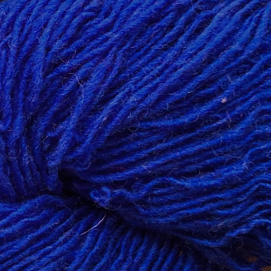 Close up on a bright cobalt blue skein of Briggs & Little Sport yarn. 