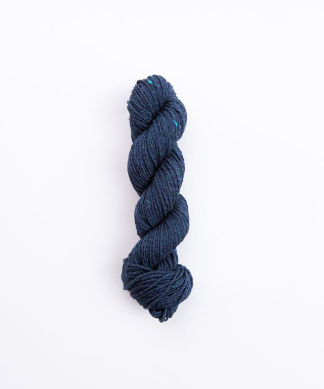 Skein of heathered dark blue Brooklyn Tweed Imbue Worsted yarn. 