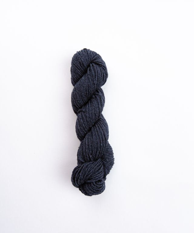 Skein of heathered charcoal Brooklyn Tweed Imbue Worsted yarn. 