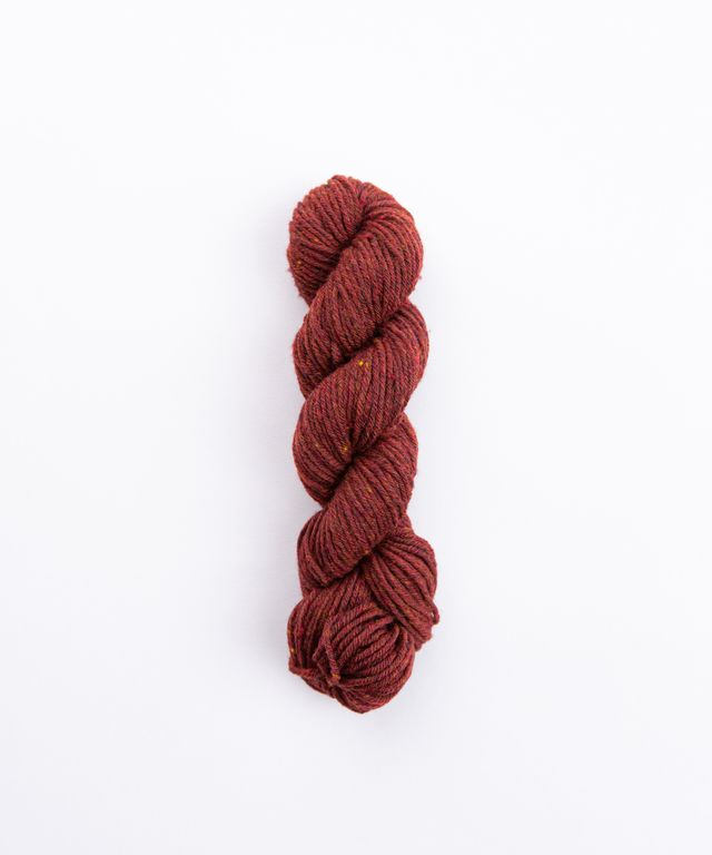 Skein of heathered burgundy Brooklyn Tweed Imbue Worsted yarn. 