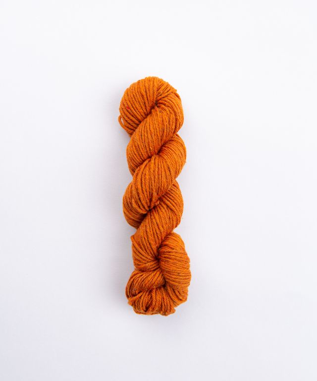 Skein of heathered orange Brooklyn Tweed Imbue Worsted yarn. 