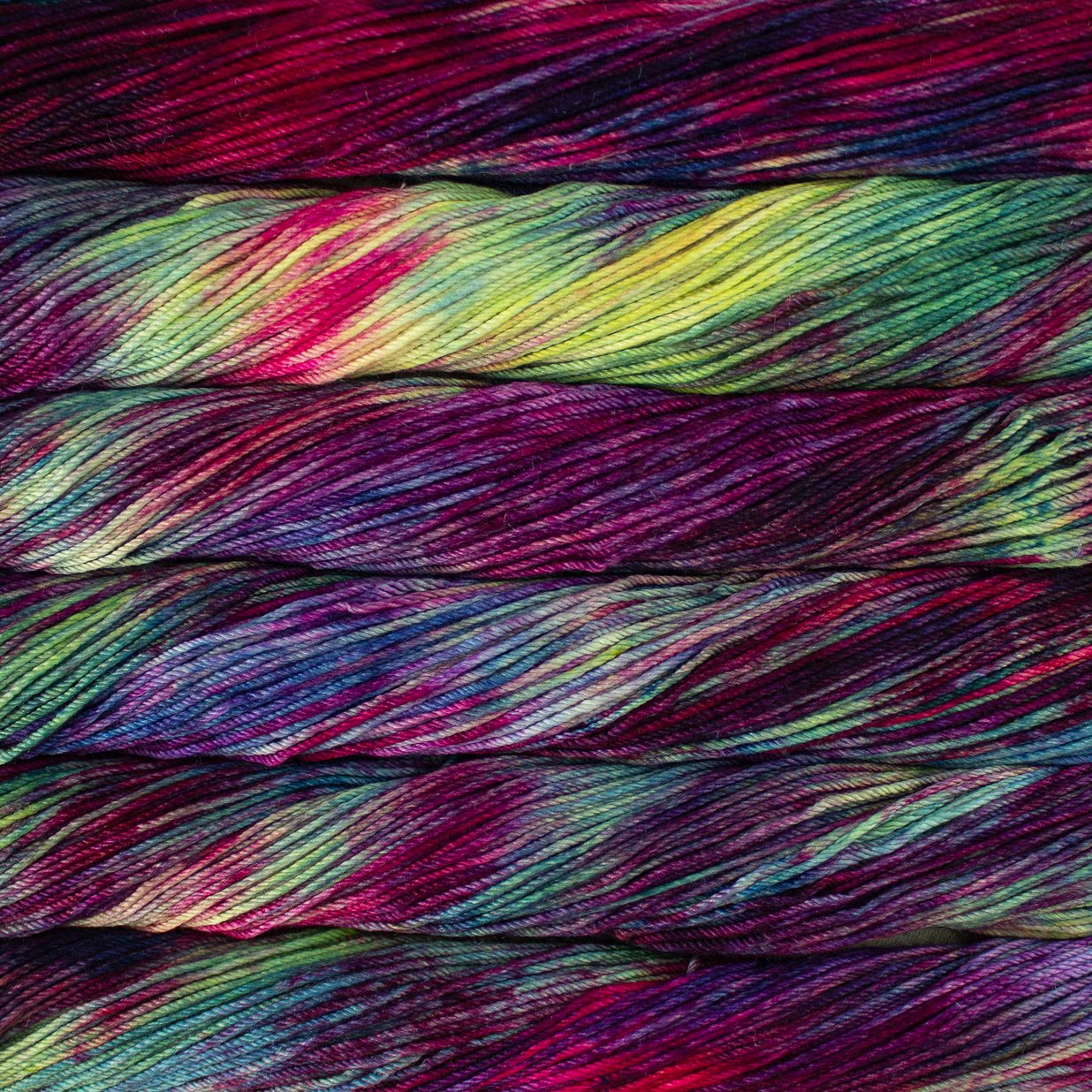 Skein of variegated purple, red, green and yellow Malabrigo Caprino yarn. 