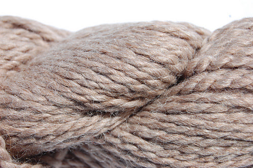 Close up on a skein of light brown Cascade Baby Alpaca Chunky yarn. 