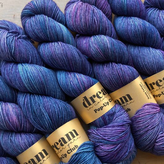 Variegated blue and purple skeins of Dream in Color Smooshy Cashmere yarn, color Snowy Twilight