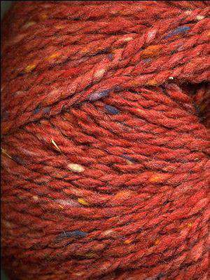 Close up on a dark rust tweed ball of Queensland Kathmandu Aran yarn. 