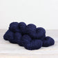 3 skeins of deep blue Fibre Co. Acadia yarn. 