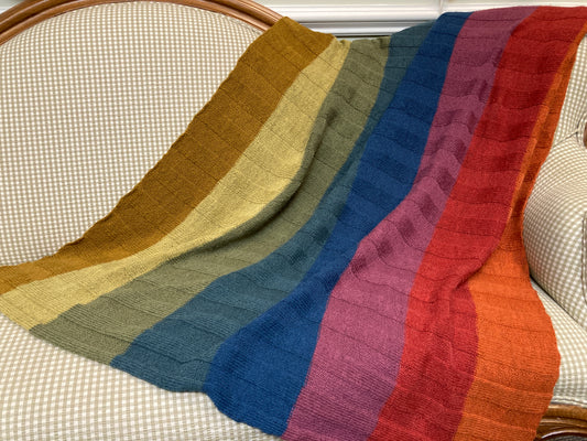 Colorful striped shawl draped over the back of a sofa at the Hillsborough Yarn Shop. 