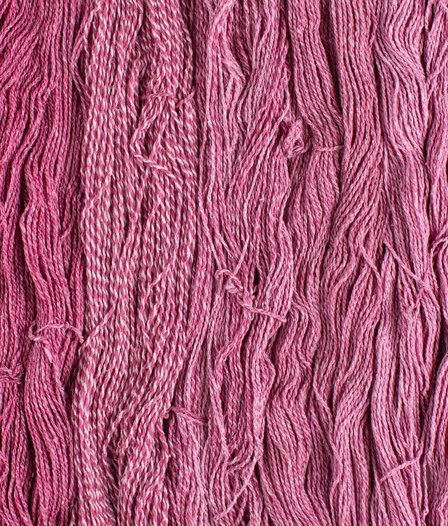 Skeins of cerise pink Brooklyn Tweed Dapple yarn. 