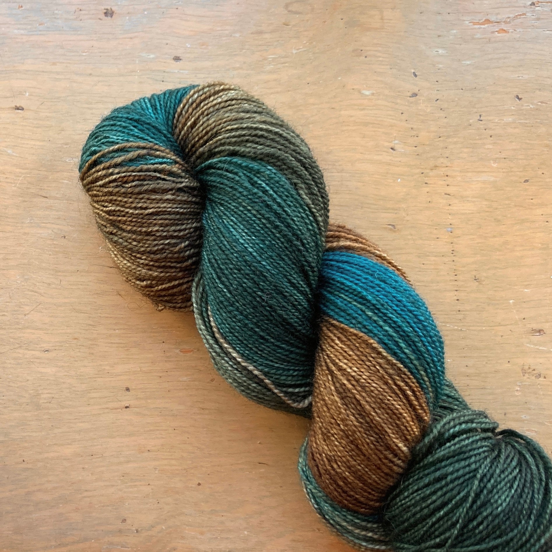 Variegated dark green, brown and teal Fleece Artist / Hand Maiden yarn, colorway Bullrush