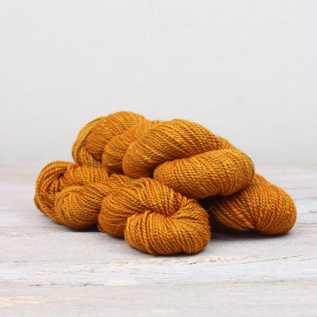 3 skeins of golden orange Fibre Co. Acadia yarn. 