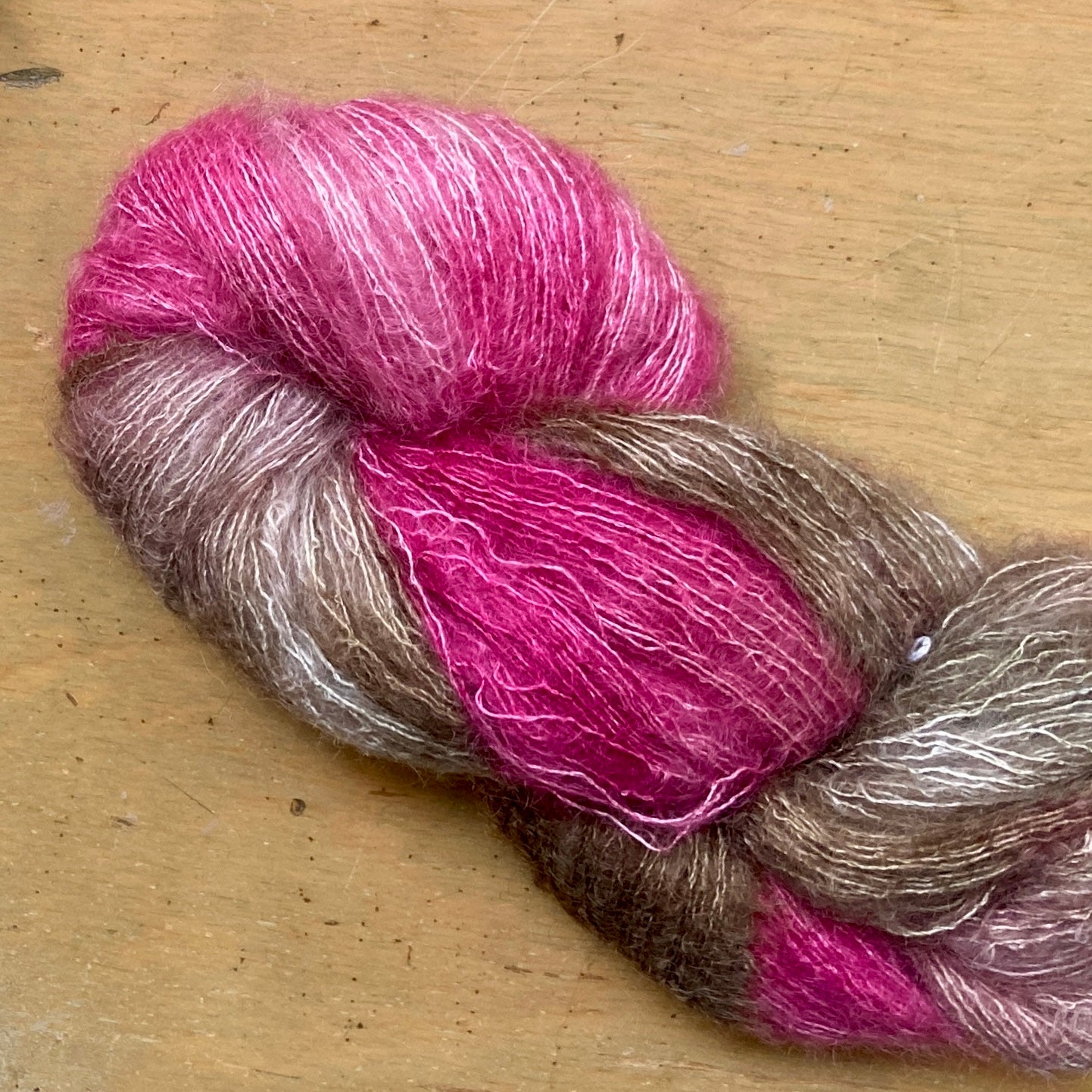 Variegated pink and brown skein of Hand Maiden Superkid Silk yarn, Sakura colorway