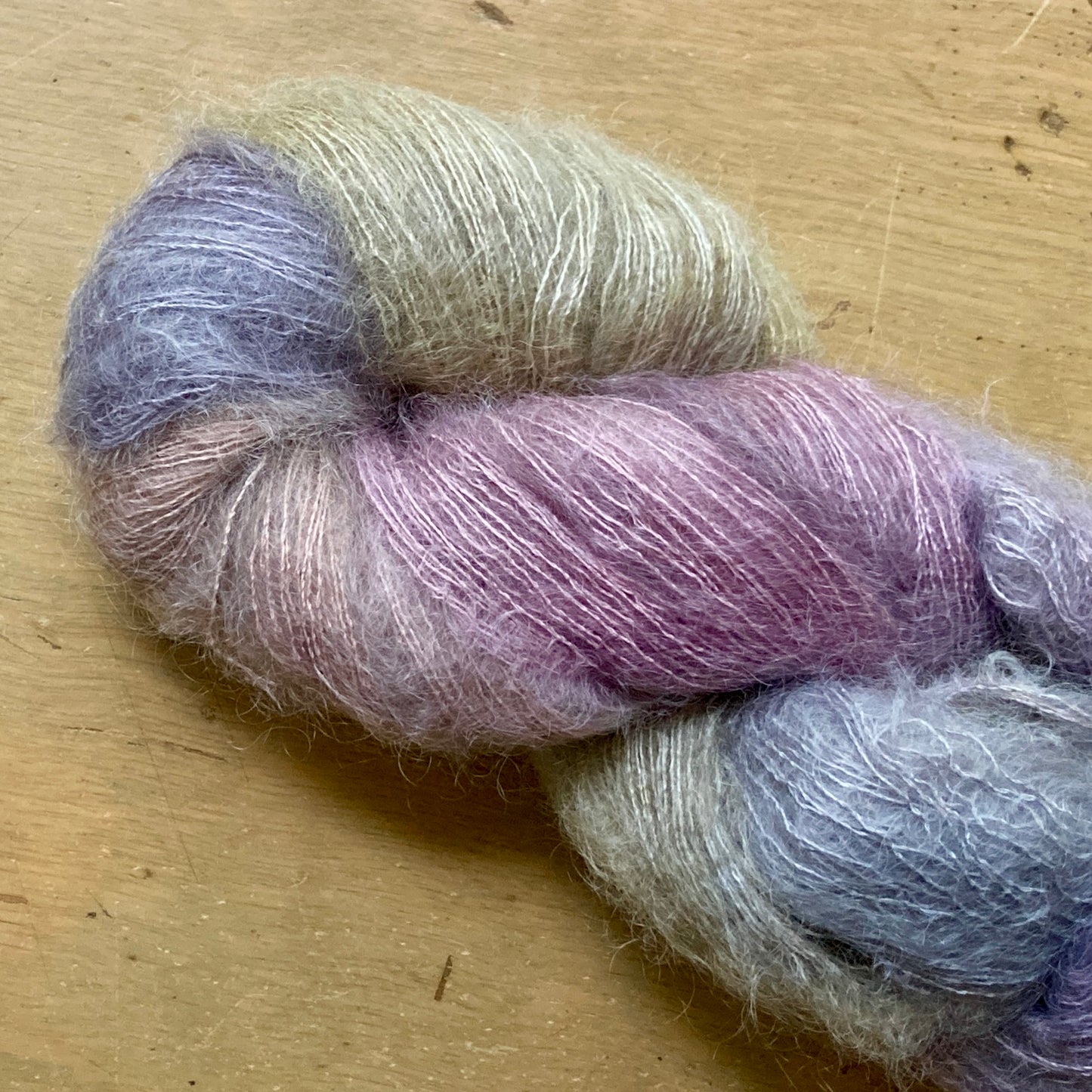 Variegated purple and gray skein of Hand Maiden Superkid Silk yarn. 